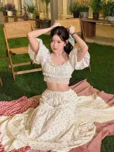 มาเบล สุชาดา เดรสสีครีมขณะนั่งกลางแจ้ง