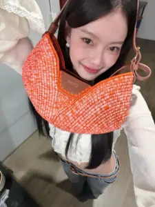 มาเบล สุชาดา ผ้าพันคอสีส้มขณะก้มหน้า