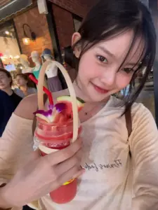 มาเบล สุชาดา เสื้อสีอ่อนขณะถือแก้ว